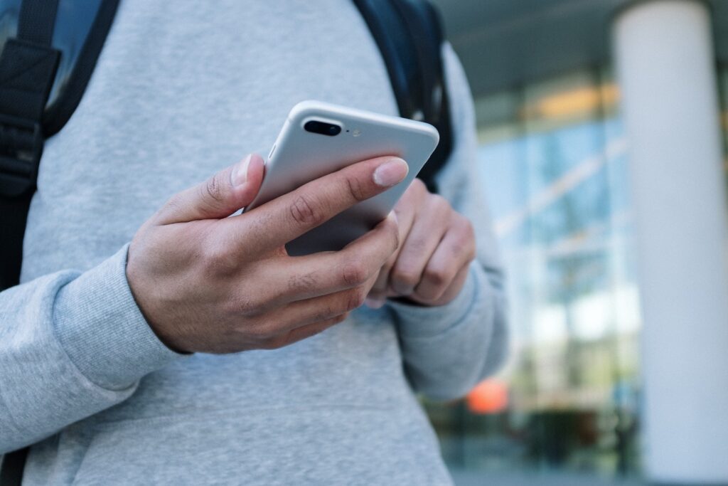 Person in Gray Long Sleeve Shirt Holding Silver Iphone 6