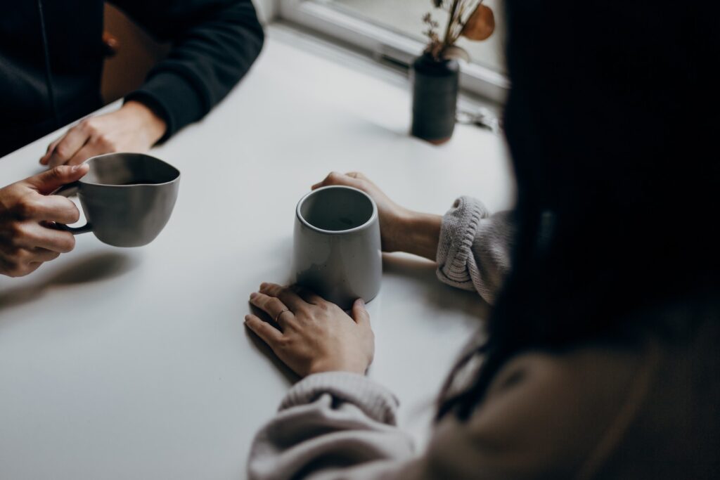 two people having a conversation over coffee