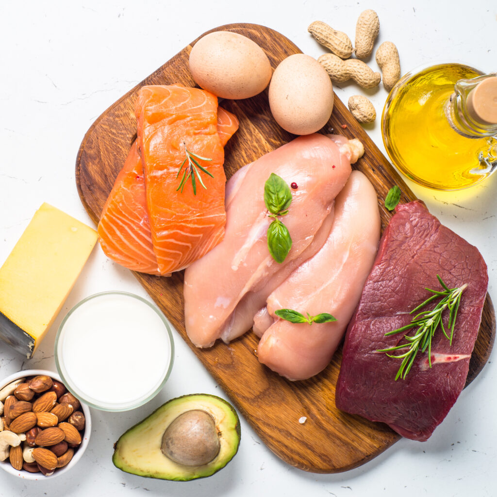 Ketogenic low carbs diet. Meat, fish, nuts,  oil, cheese, milk and avocado on white background. Top view.