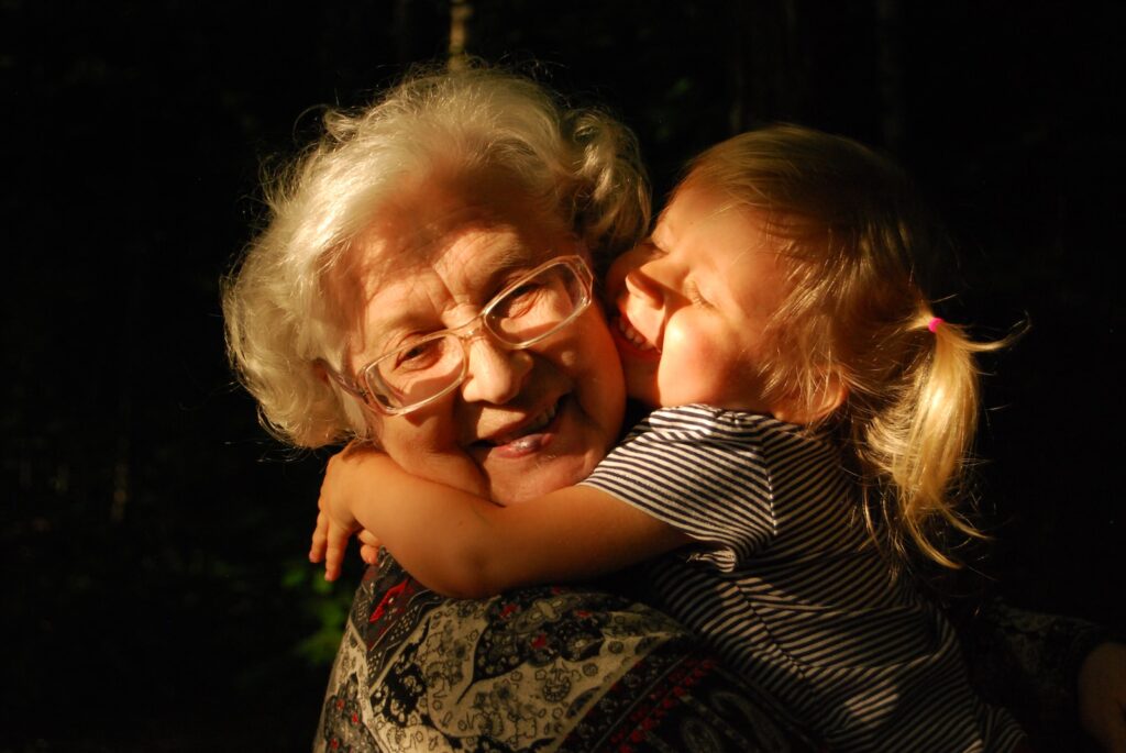 small granddaughter hugging senior grandmother