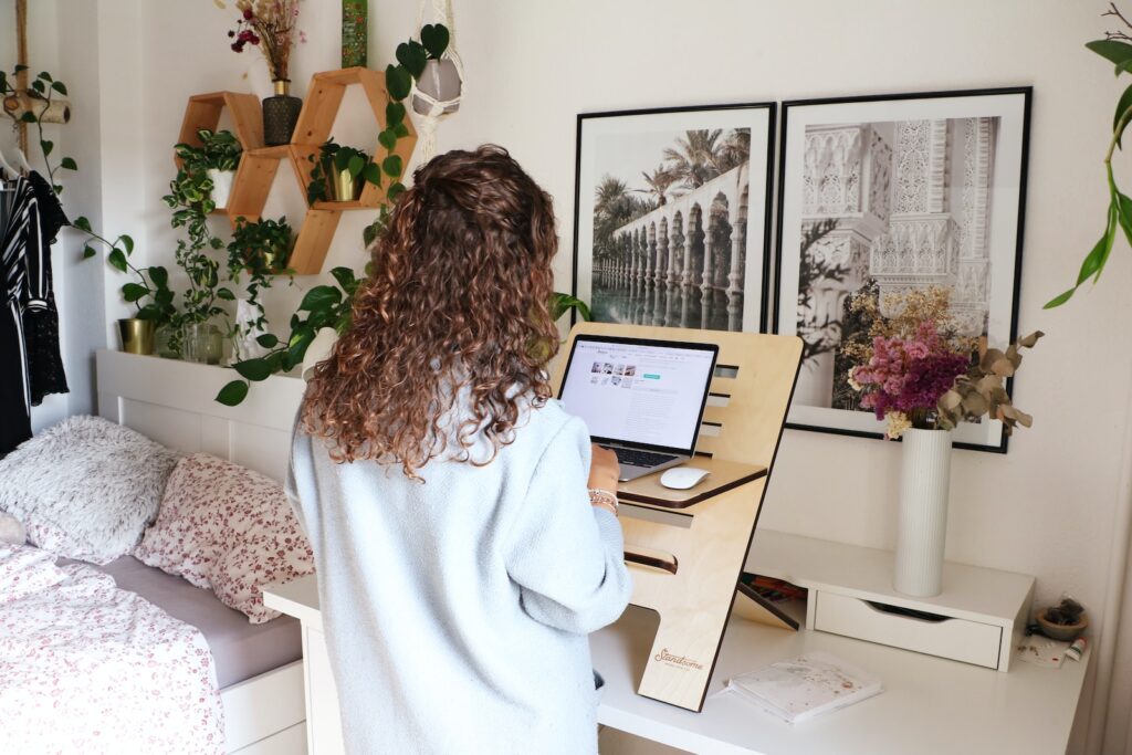 a woman using a standing desk with a laptop