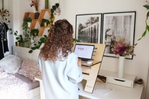 a woman using a standing desk with a laptop