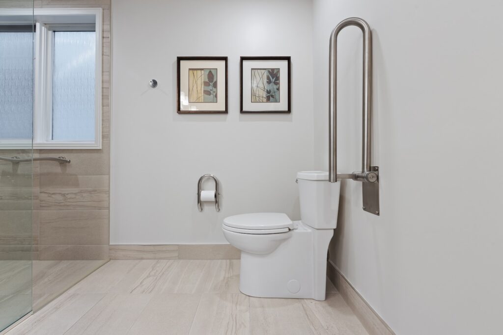 a bathroom with a toilet and a shower with grab bars for accessibility as part of adapting home for chronic pain