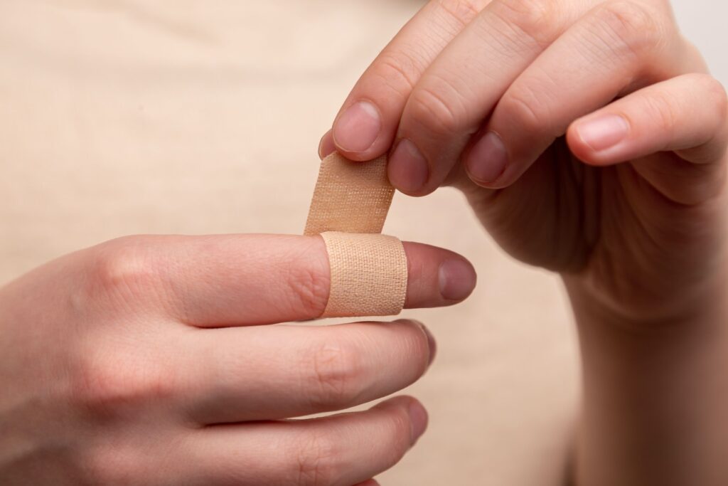 close up view of someone putting a bandaid on their index finger