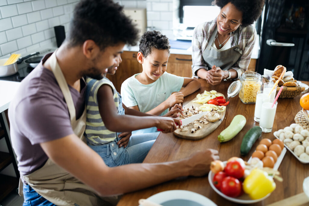 Happy family cooking together healthy food in the kitchen